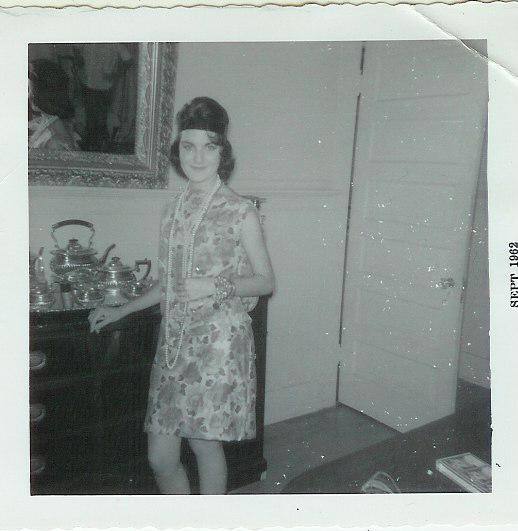Megan's mother, age 18 in September 1962, dressed in a 20's flapper dress with long pearls. She's in her mother's formal dining room.