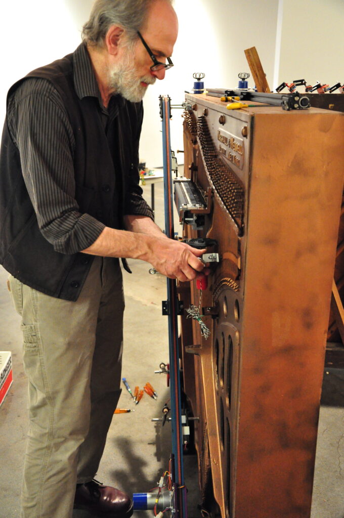the artist Trimpin takes a tool to the upright "player piano" of his exhibit